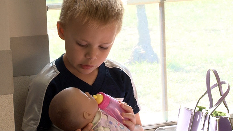 Boy with baby doll