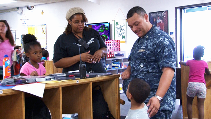 A caregiver speaks with a child and his parent