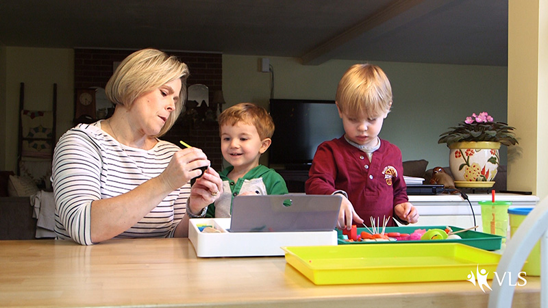 A caregiver and children engage in crafts and play