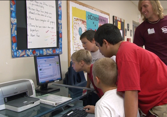 School-Agers look up the rules for a pool game to help settle a conflict in the program.