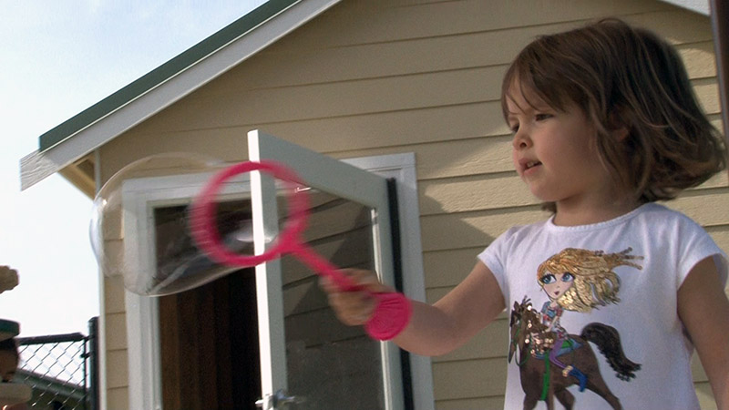 Preschool girl playing with bubbles