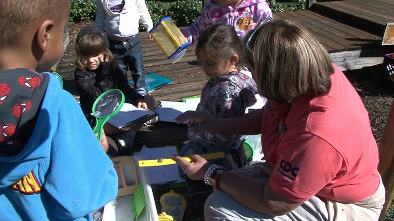 Caregiver playing with preschoolers